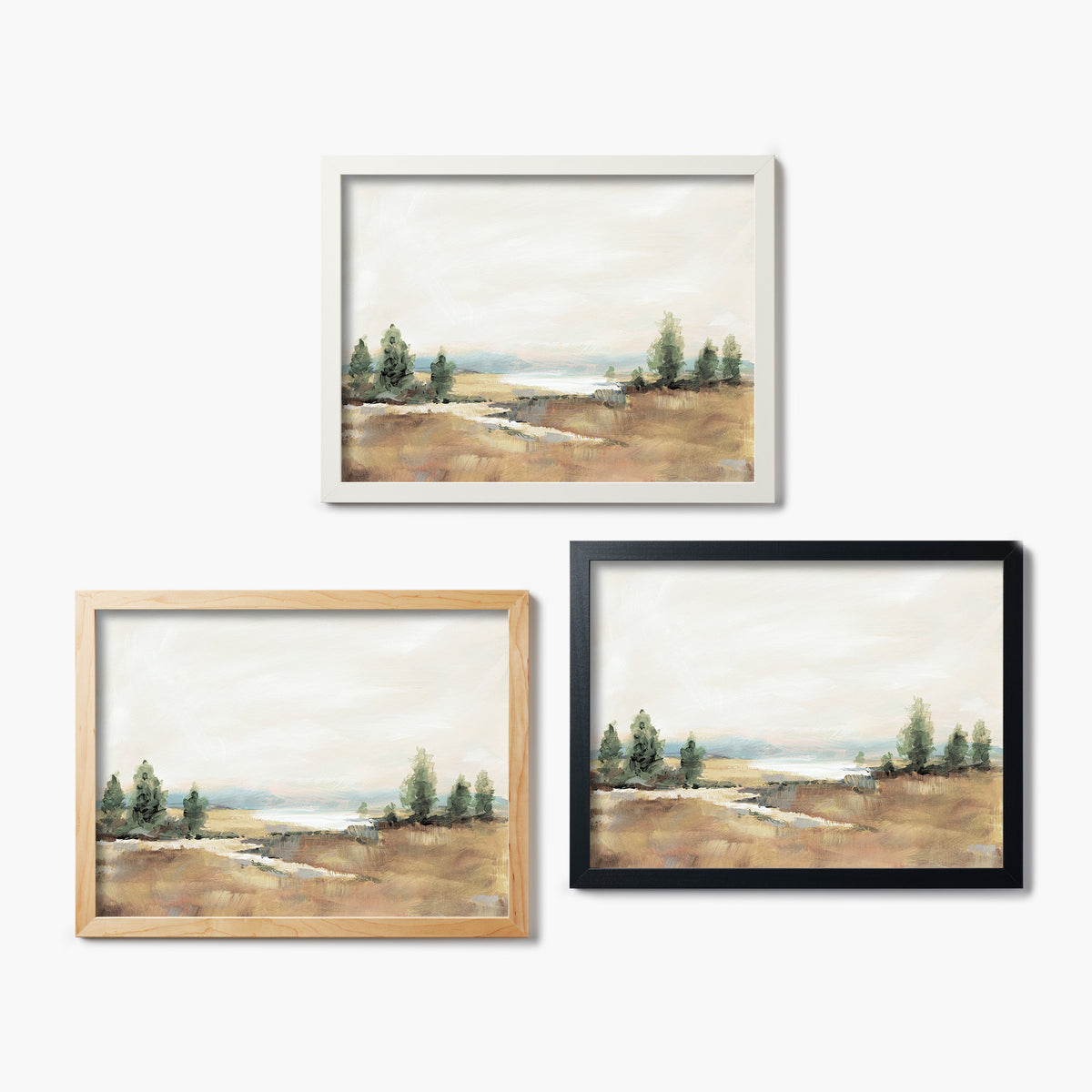 Three framed glass prints of a landscape painting on a white background