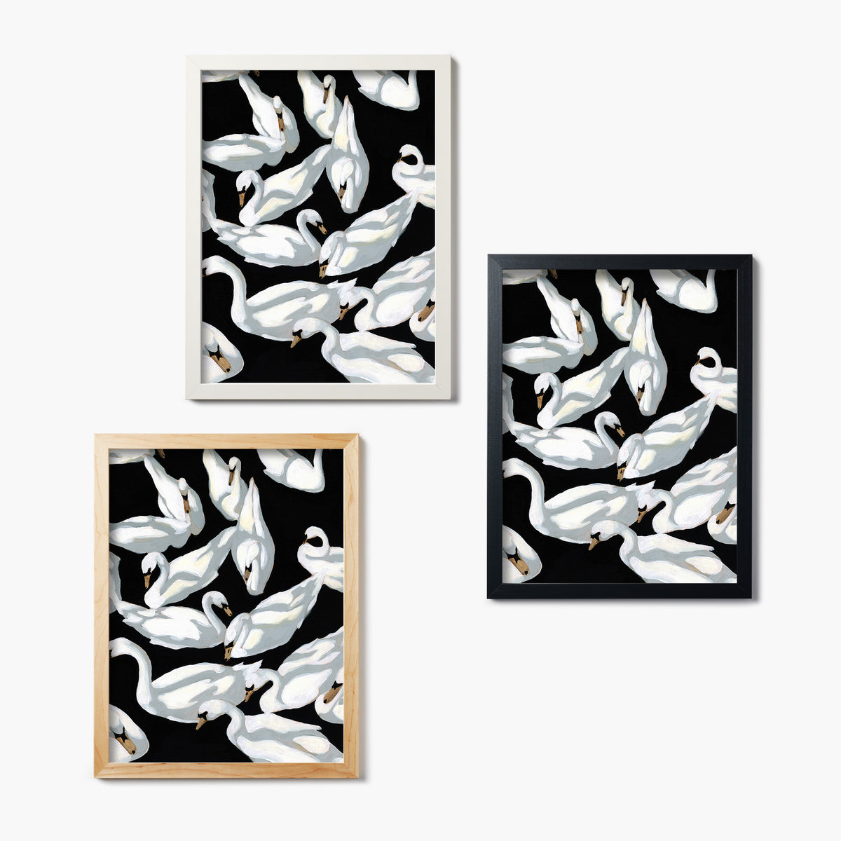 Set of three framed glass prints of white swan designs on black backgrounds.
