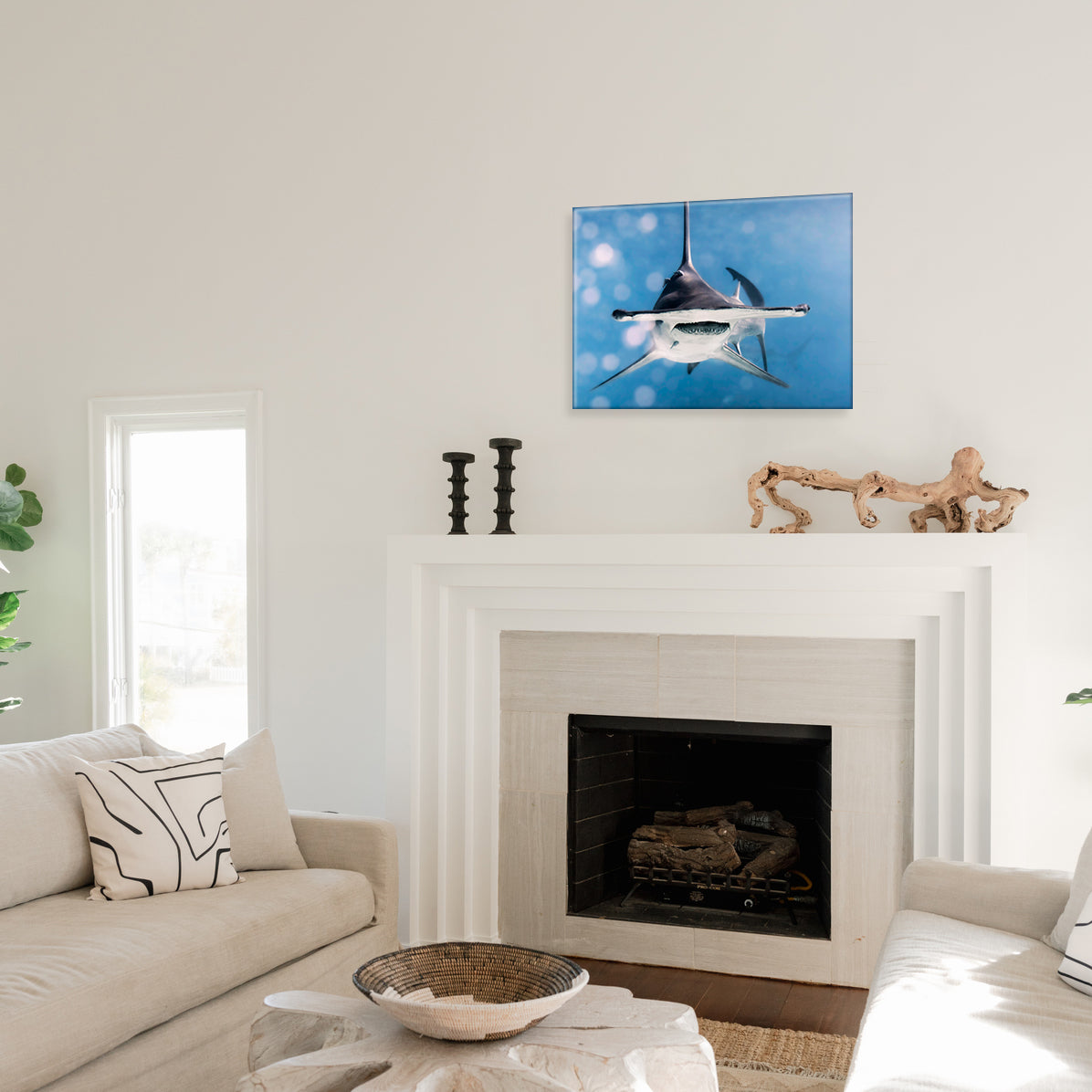 Living room with a fireplace and a hammerhead shark glass print mounted above it on the wall