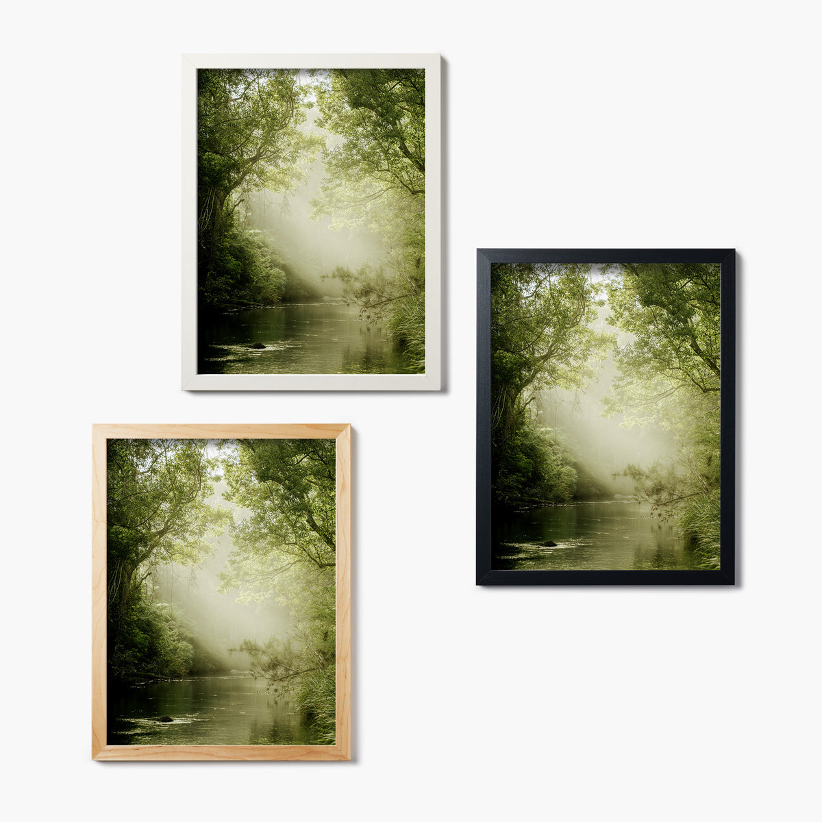 Three framed glass prints of a misty green forest scene with a river on a white background