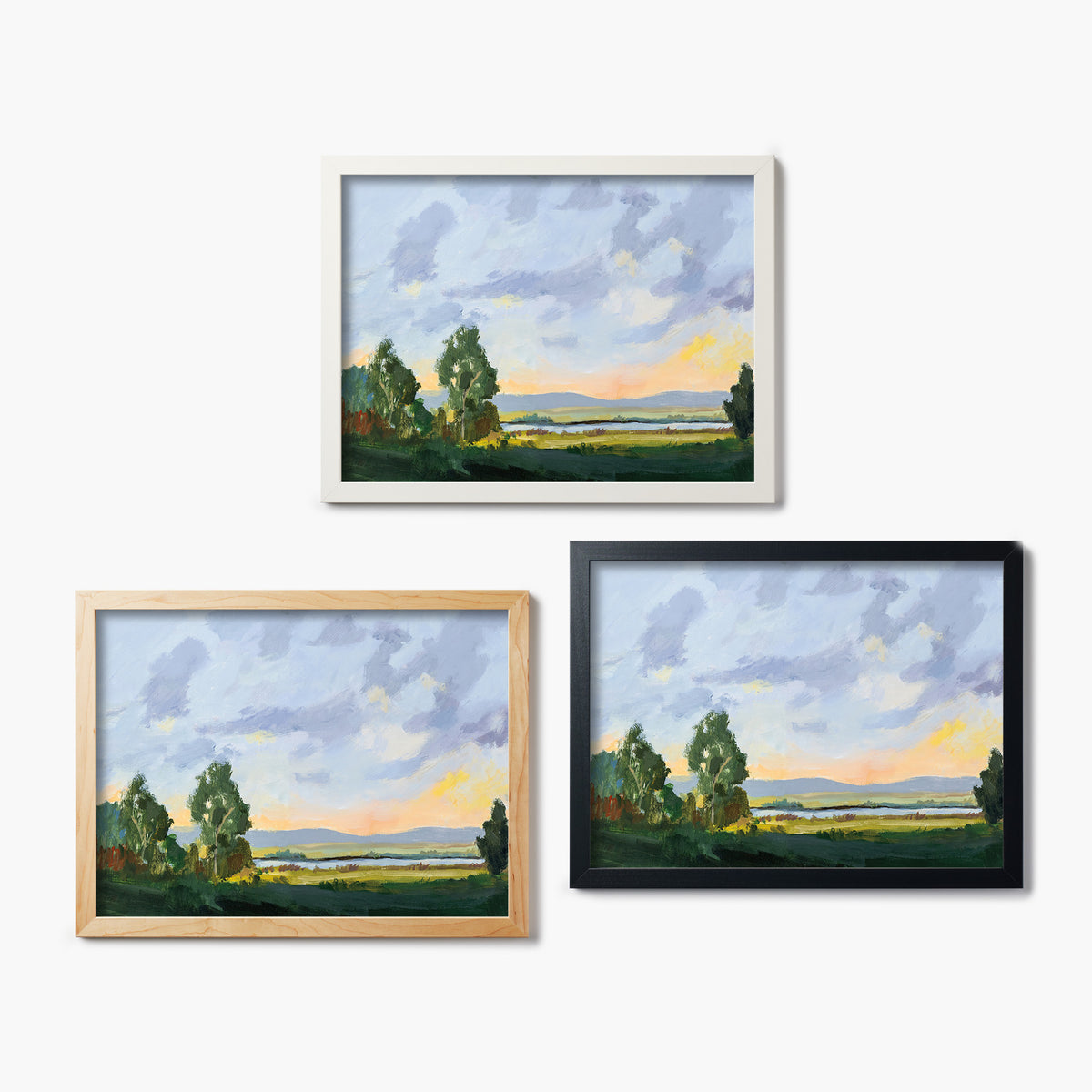 Three framed glass prints of a landscape painting of a green field on a white background