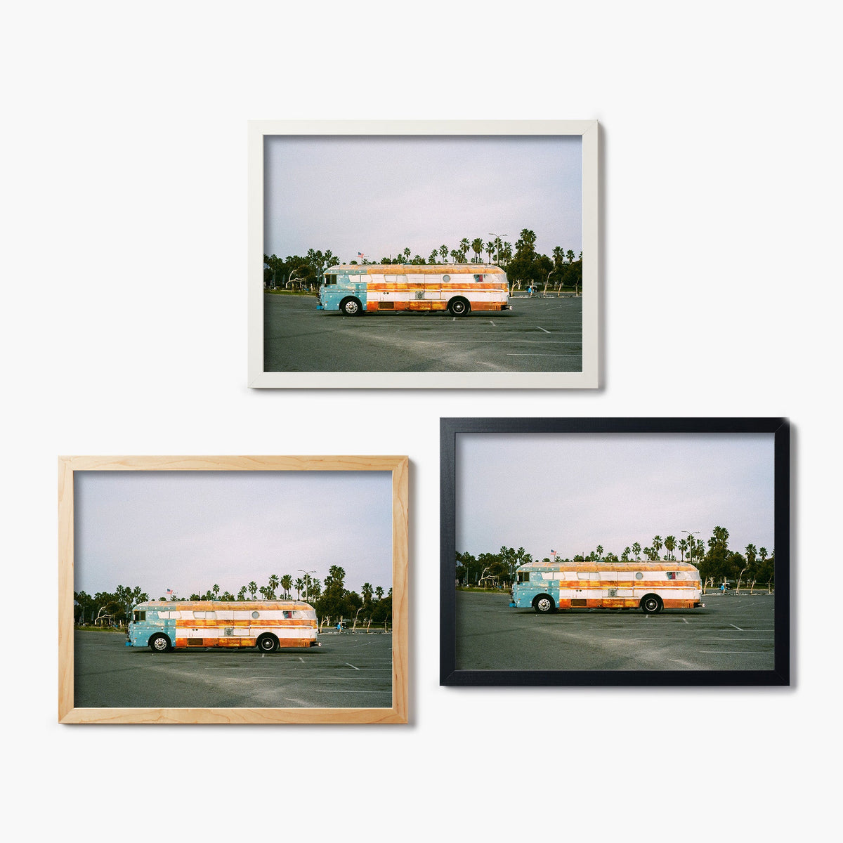 Three framed glass prints of a colorful bus in a parking lot with palm trees.