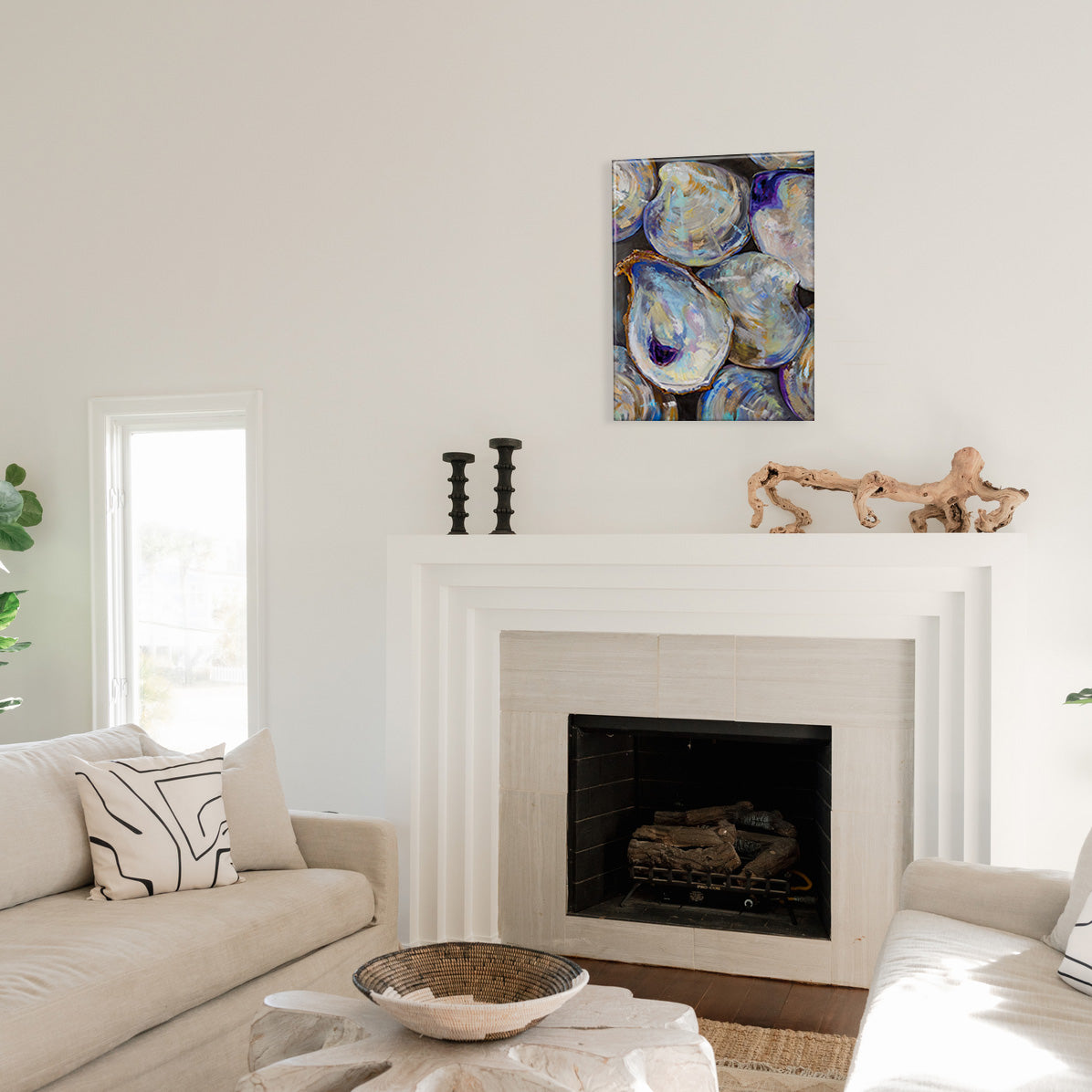 Living room with a fireplace, a glass print of painted shells, and decorative items.