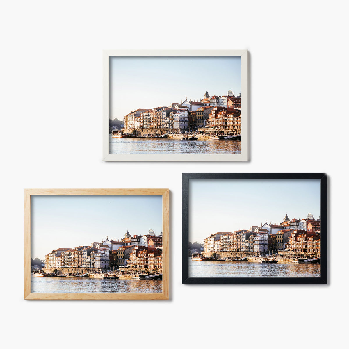Three framed glass prints of a Portugal waterfront cityscape with buildings and water.
