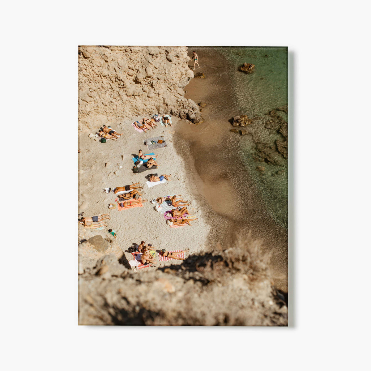 Aerial view of people on a beach with sand and water.