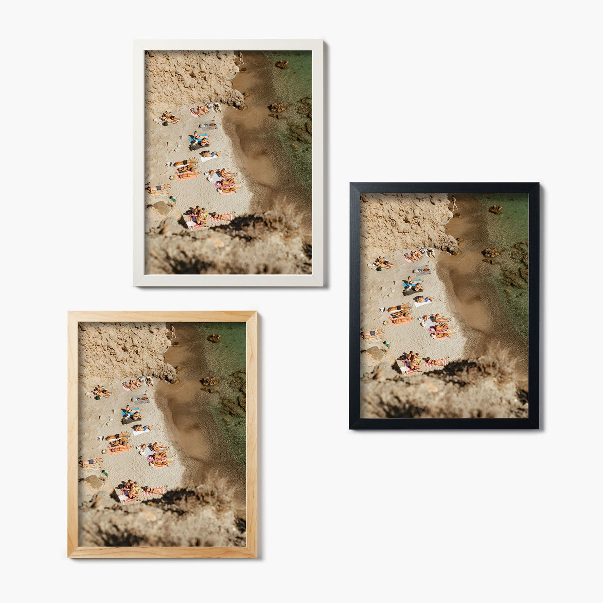 Three framed glass prints of an aerial beach scene with people sunbathing
