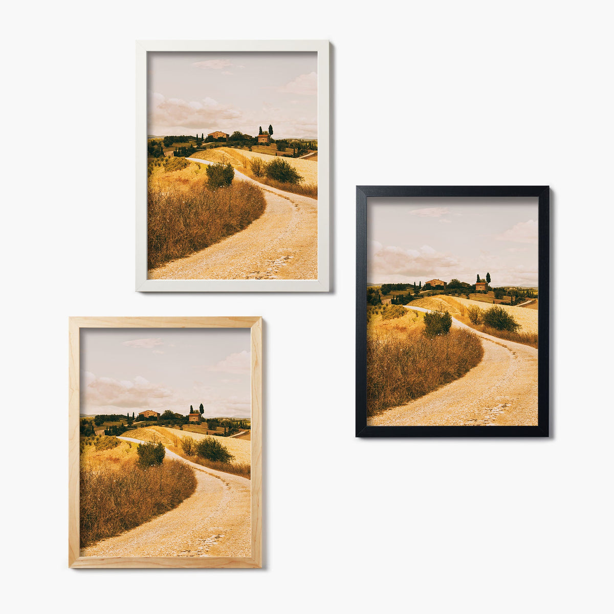 Three framed glass prints of a scenic landscape with a winding road and hills on a white background.
