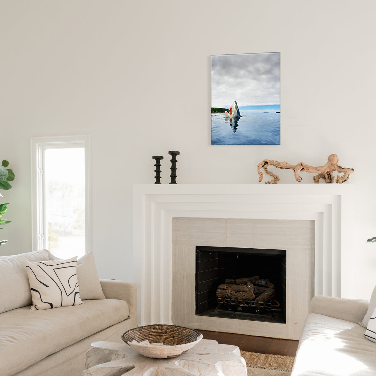 Living room with a fireplace and a glass print of a shark's head emerging from water on a clear day